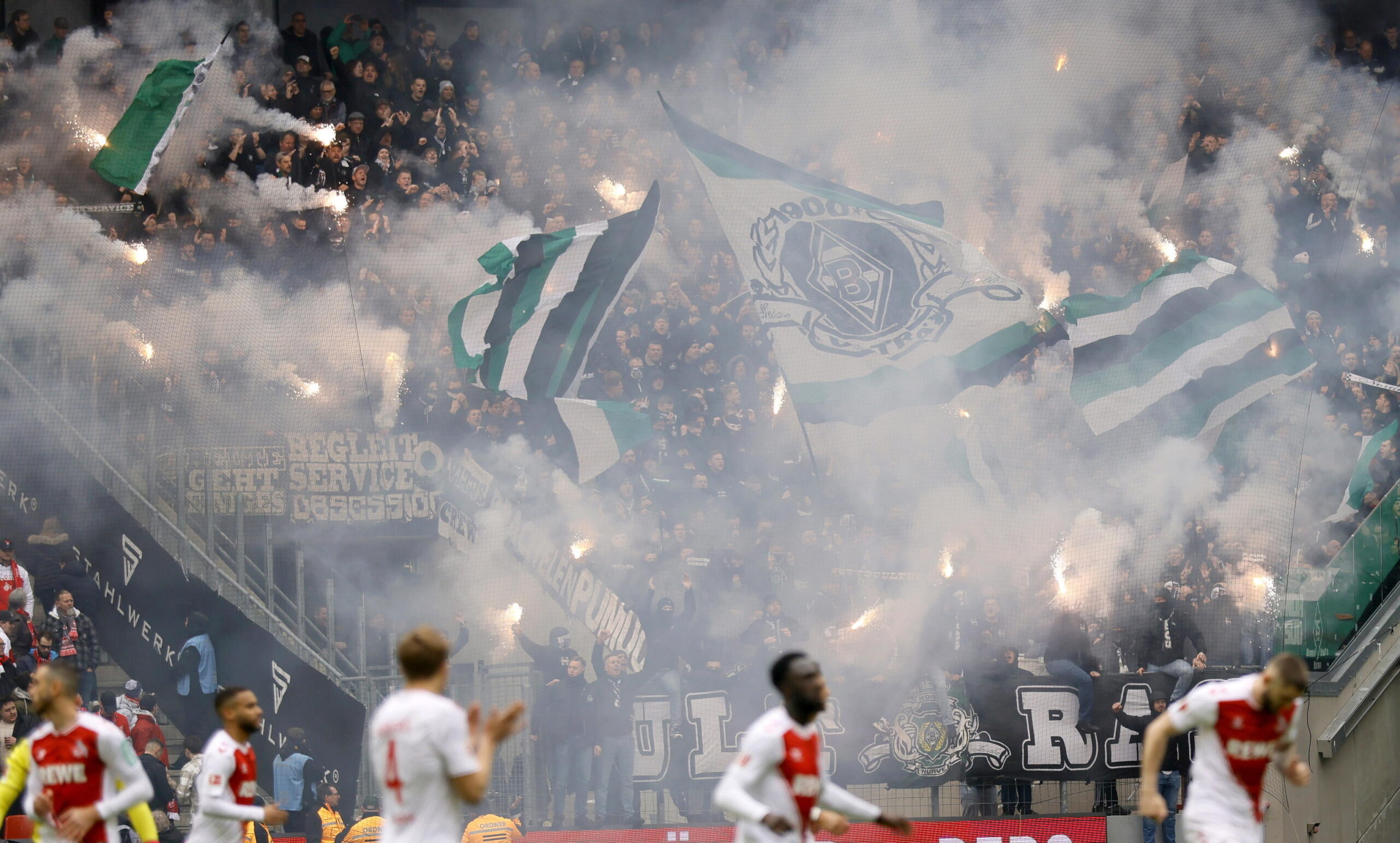 epa10555459 Fans of Moenchengladbach light flares during the German Bundesliga soccer match between 1. FC Cologne and Borussia Moenchengladbach in Cologne, Germany, 02 April 2023.  EPA/RONALD WITTEK CONDITIONS - ATTENTION: The DFL regulations prohibit any use of photographs as image sequences and/or quasi-video.